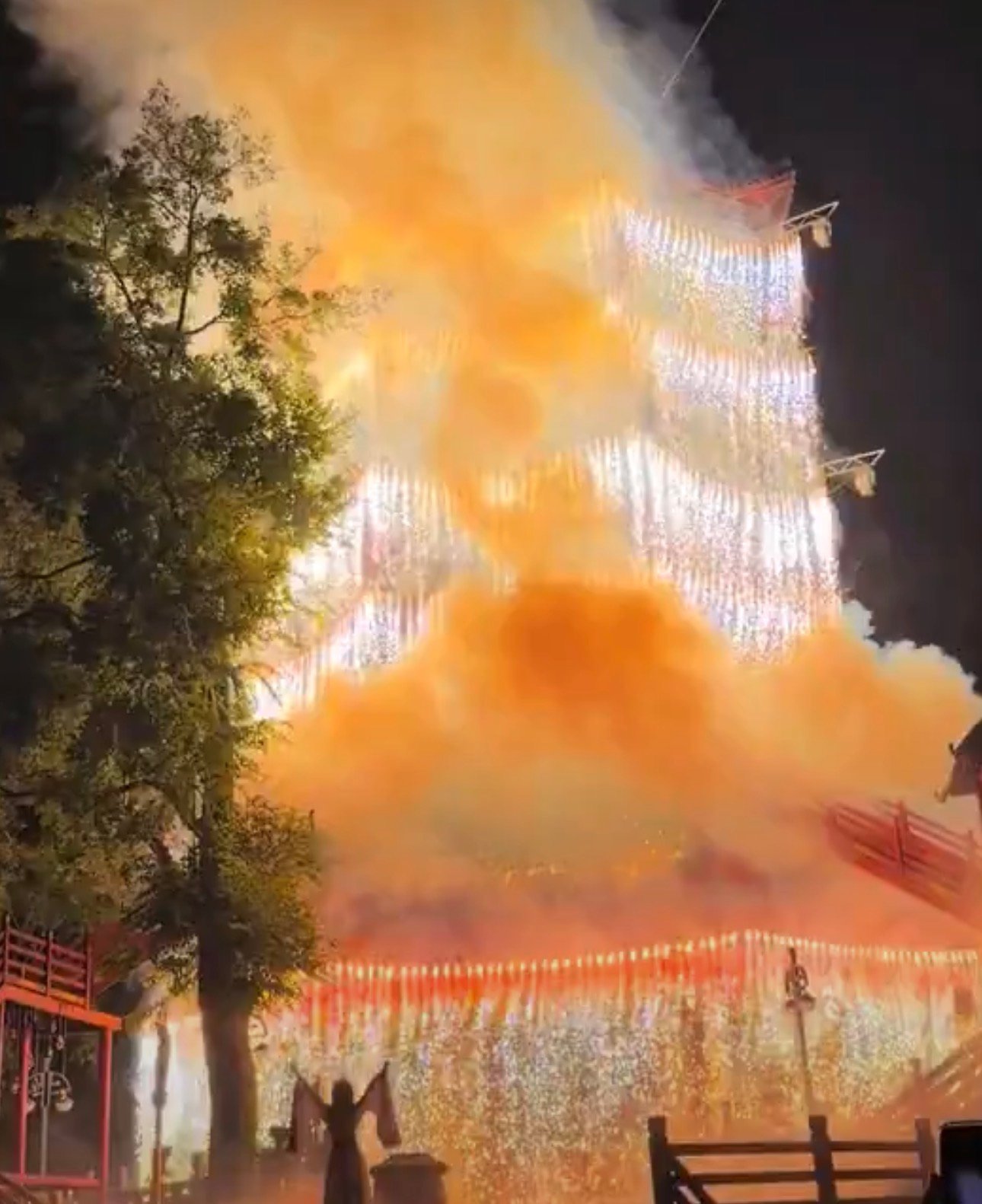 Una torre china deslumbra con cascada de fuegos artificiales